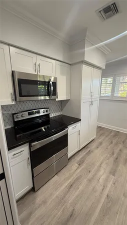 a kitchen with granite countertop a stove and a refrigerator