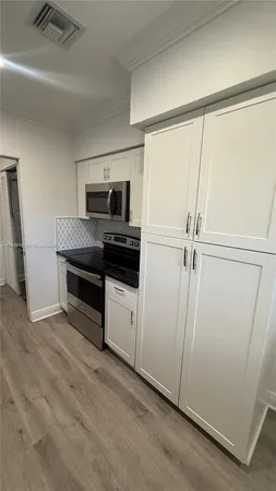 a kitchen with a refrigerator and a sink