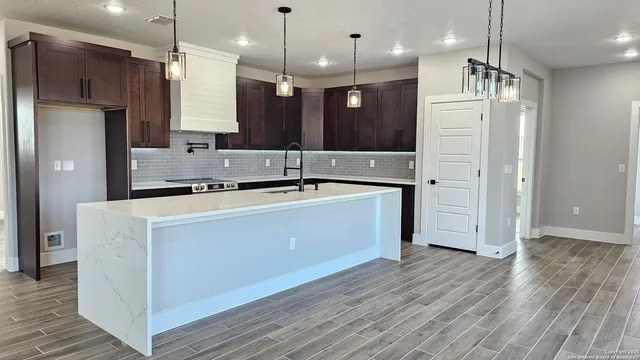 a kitchen with kitchen island a sink stainless steel appliances and refrigerator