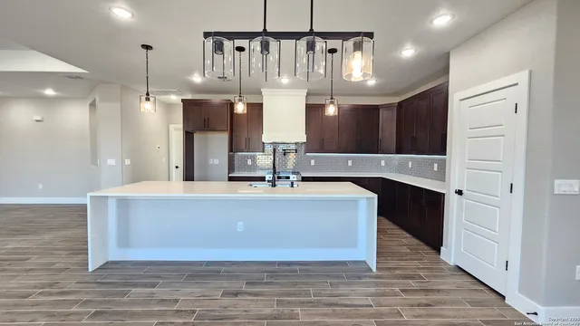 a view of living room kitchen with stainless steel appliances granite countertop cabinets and fireplace