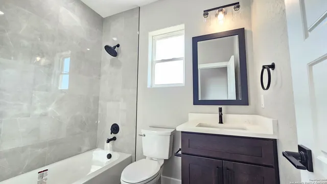 a bathroom with a sink a toilet and shower