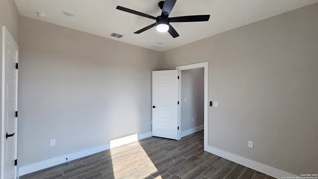 a view of empty room with wooden floor