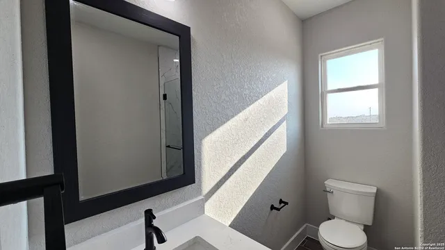 a white toilet sitting next to a window