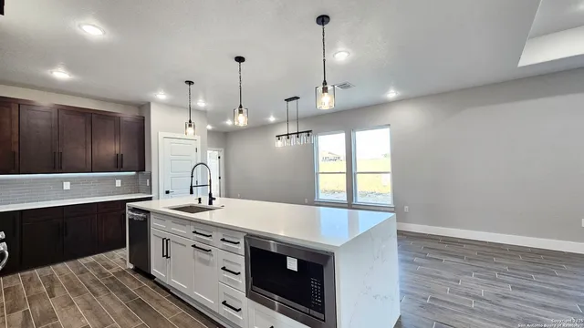 a kitchen with a sink a stove and cabinets