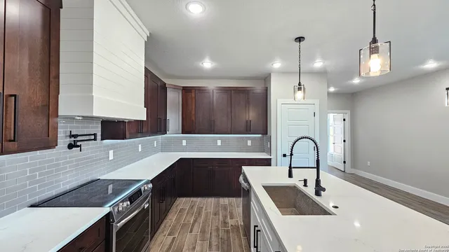 a kitchen with kitchen island a sink stove and wooden cabinets