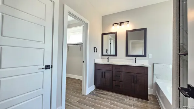 a bathroom with a double vanity sink and mirror