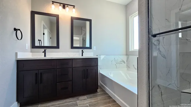 a bathroom with a tub sink and mirror