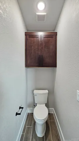 a bathroom with a toilet and a mirror