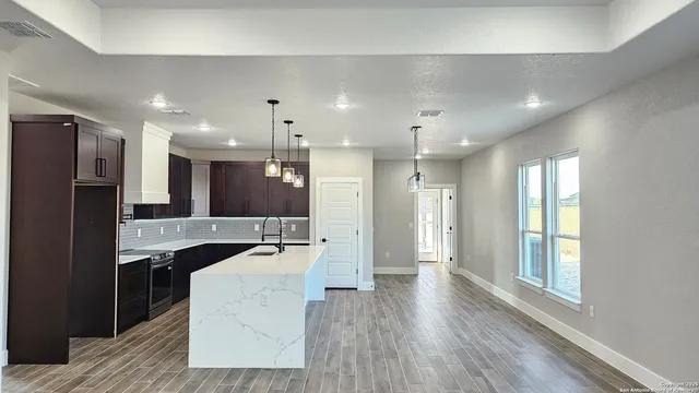 a large kitchen with stainless steel appliances kitchen island a large counter top and a refrigerator