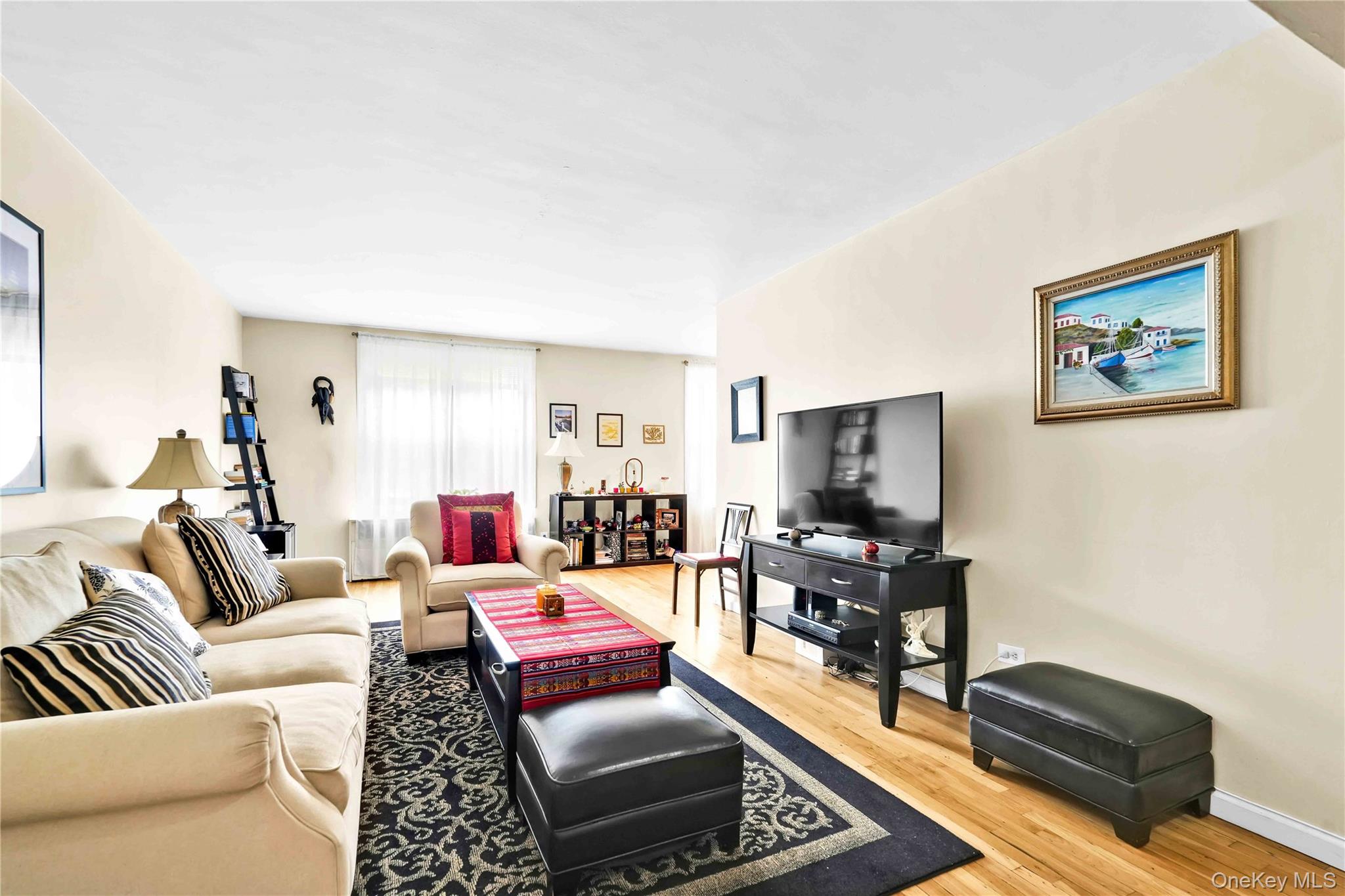 209-10 41st Avenue, Unit 2J Queens, NY 11361 - Photo 16 of 35 a living room with furniture and a flat screen tv
