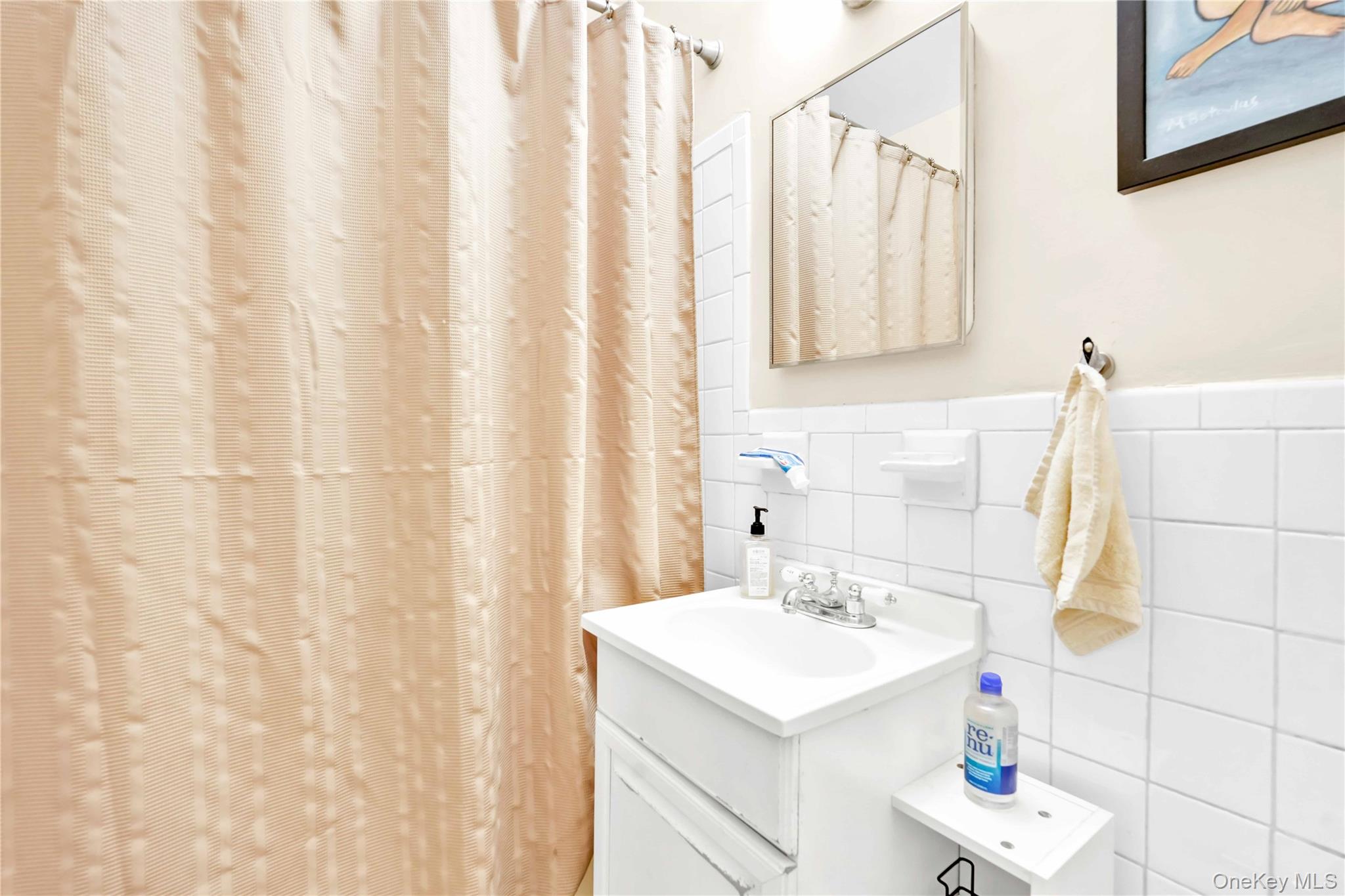 209-10 41st Avenue, Unit 2J Queens, NY 11361 - Photo 23 of 35 a bathroom with a sink and a mirror