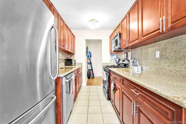 a kitchen with stainless steel appliances granite countertop a lot of cabinets and wooden floor