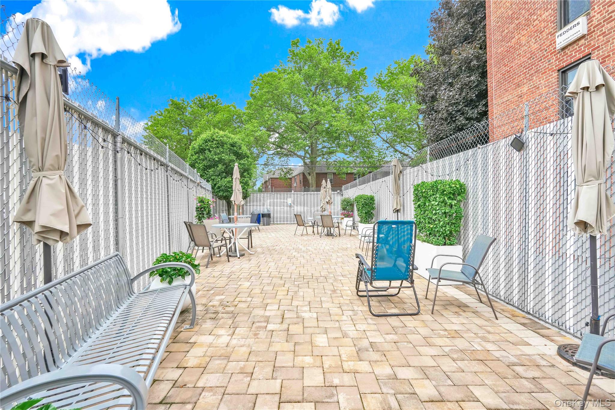 209-10 41st Avenue, Unit 2J Queens, NY 11361 - Photo 33 of 35 a view of a patio with table and chairs potted plants with wooden fence