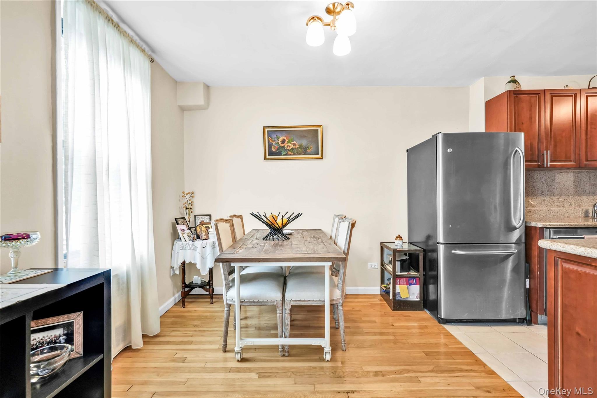 209-10 41st Avenue, Unit 2J Queens, NY 11361 - Photo 6 of 35 a dining room with furniture a fireplace and wooden floor