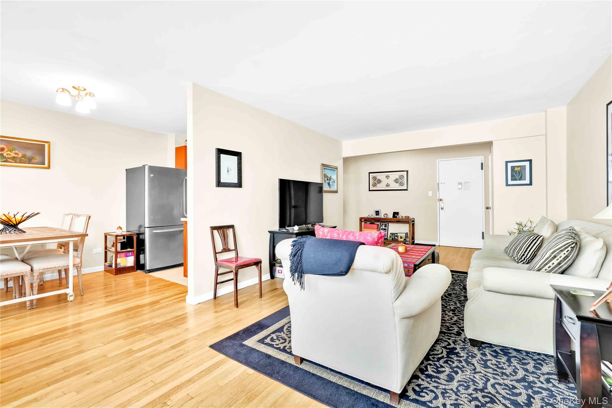 209-10 41st Avenue, Unit 2J Queens, NY 11361 - Photo 10 of 35 a living room with furniture and a flat screen tv