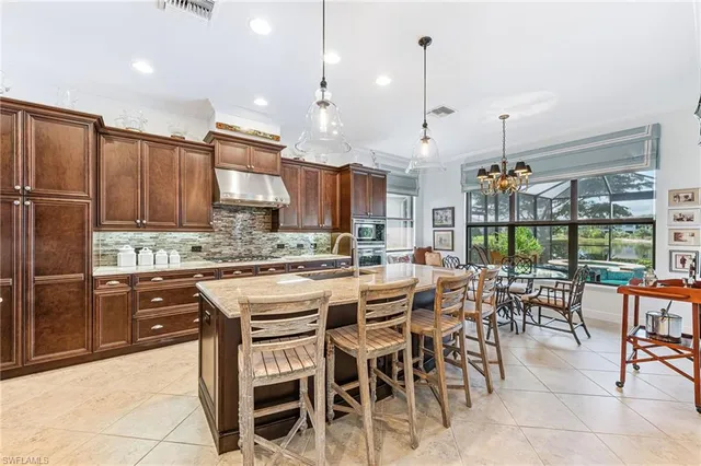 a kitchen with stainless steel appliances granite countertop table chairs sink and cabinets