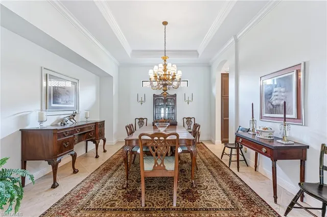 a dining room with furniture a chandelier and window