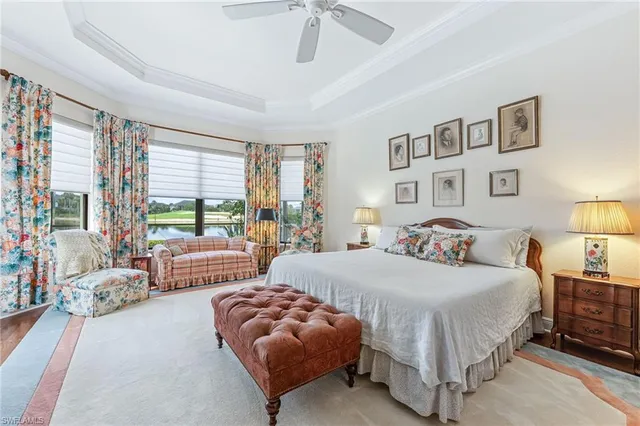 a bedroom with a large bed couch and two large window