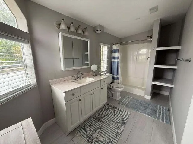 a spacious bathroom with a double vanity sink a mirror and a shower