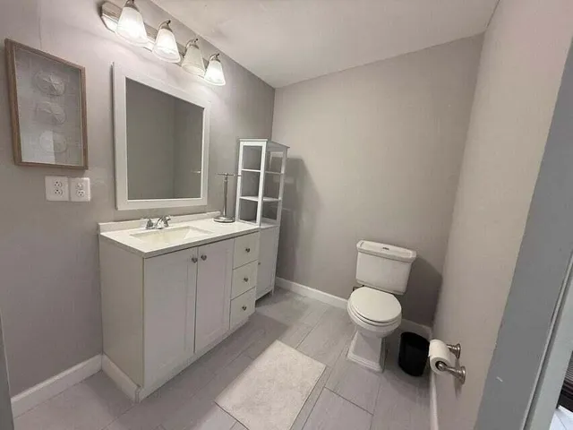 a bathroom with a toilet sink and mirror