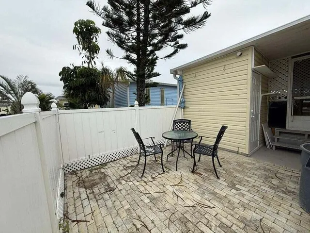 a view of a patio with table and chairs with wooden floor and fence
