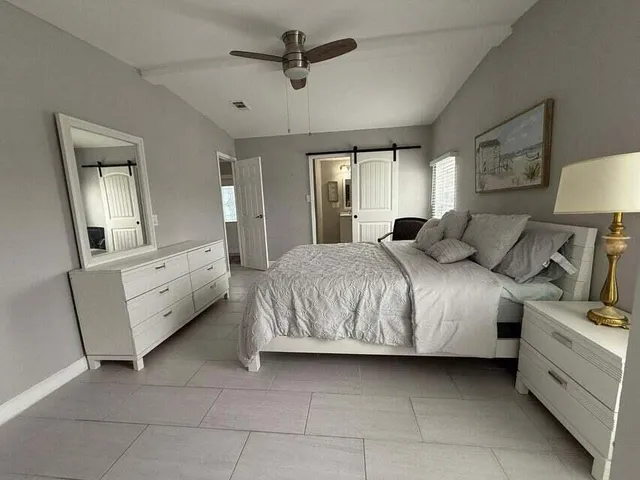 a bedroom with a large bed and a chandelier