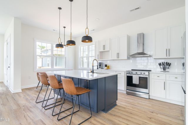 a kitchen with stainless steel appliances granite countertop a sink a stove and a refrigerator