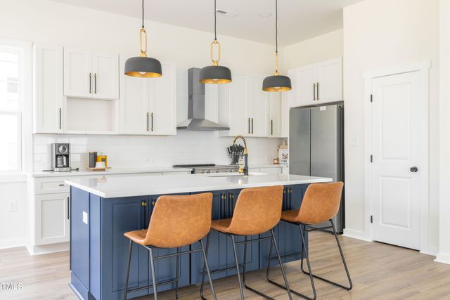 a kitchen with kitchen island granite countertop a sink a counter space and cabinets