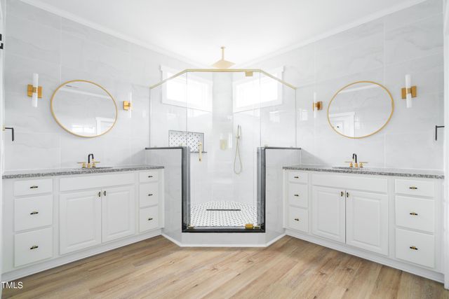 a bathroom with a granite countertop sink a mirror and a shower