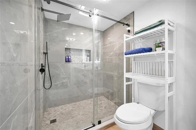 a bathroom with a shower sink vanity mirror and toilet