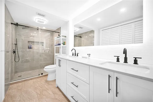 a bathroom with a toilet a sink a mirror a bathtub and shower