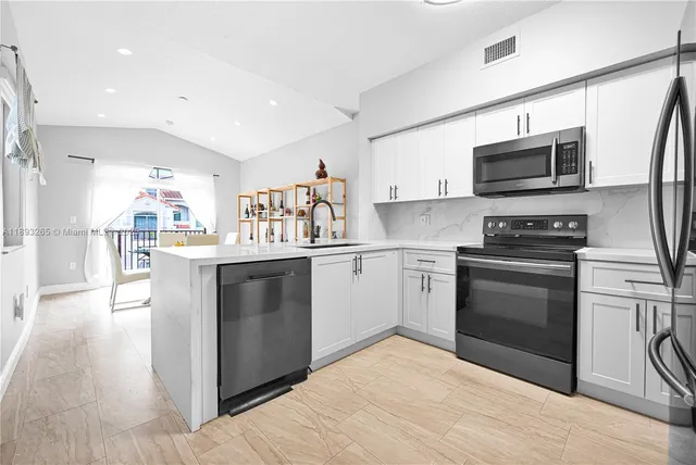 a metallic refrigerator freezer sitting in a kitchen