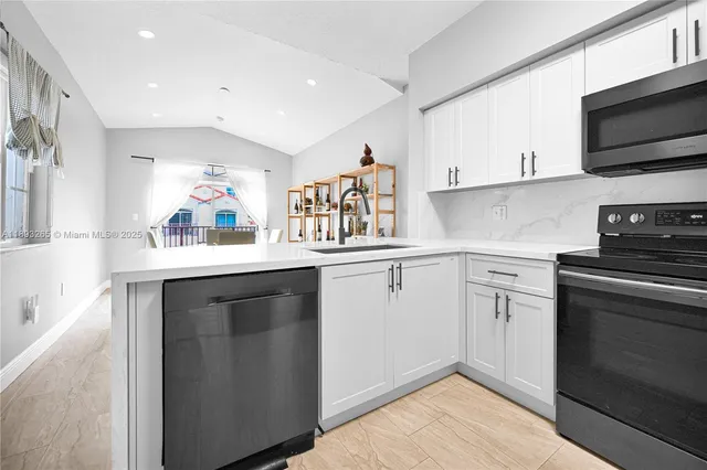 a living room with stainless steel appliances furniture dining table and chairs