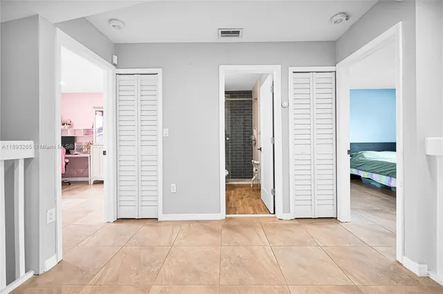a large bed sitting in a bedroom next to a window