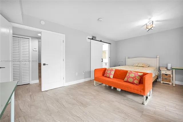 a bedroom with a bed and next to a window