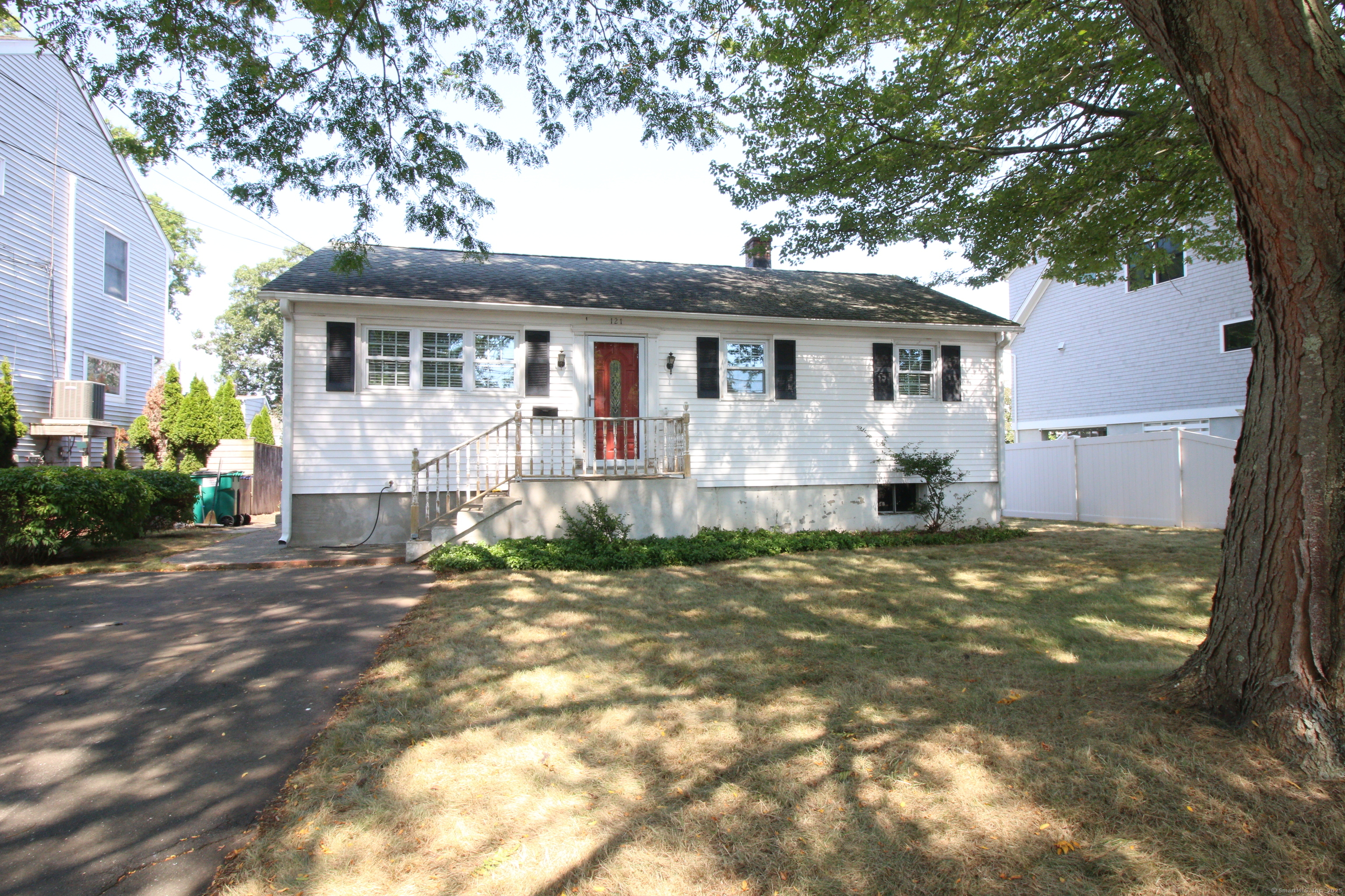 a view of a yard in front of a house with large tree
