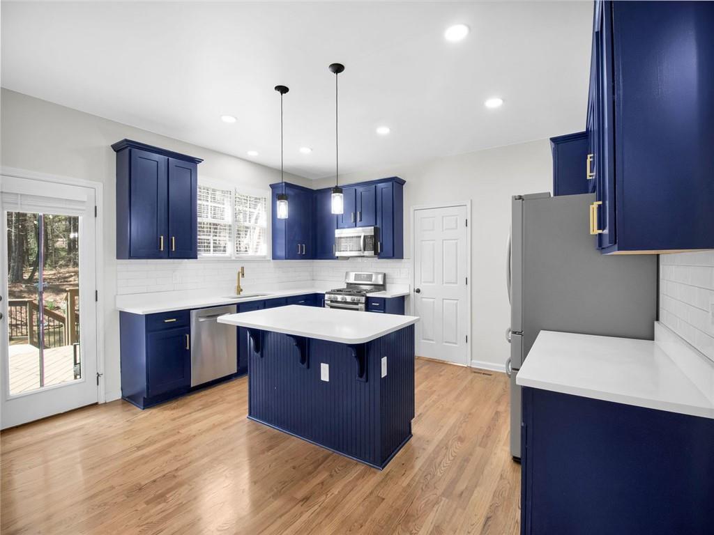 8840 Appling Ridge Cumming, GA 30041 - Photo 27 of 87 a open kitchen with stainless steel appliances granite countertop a stove a sink dishwasher a refrigerator and a oven with wooden floor