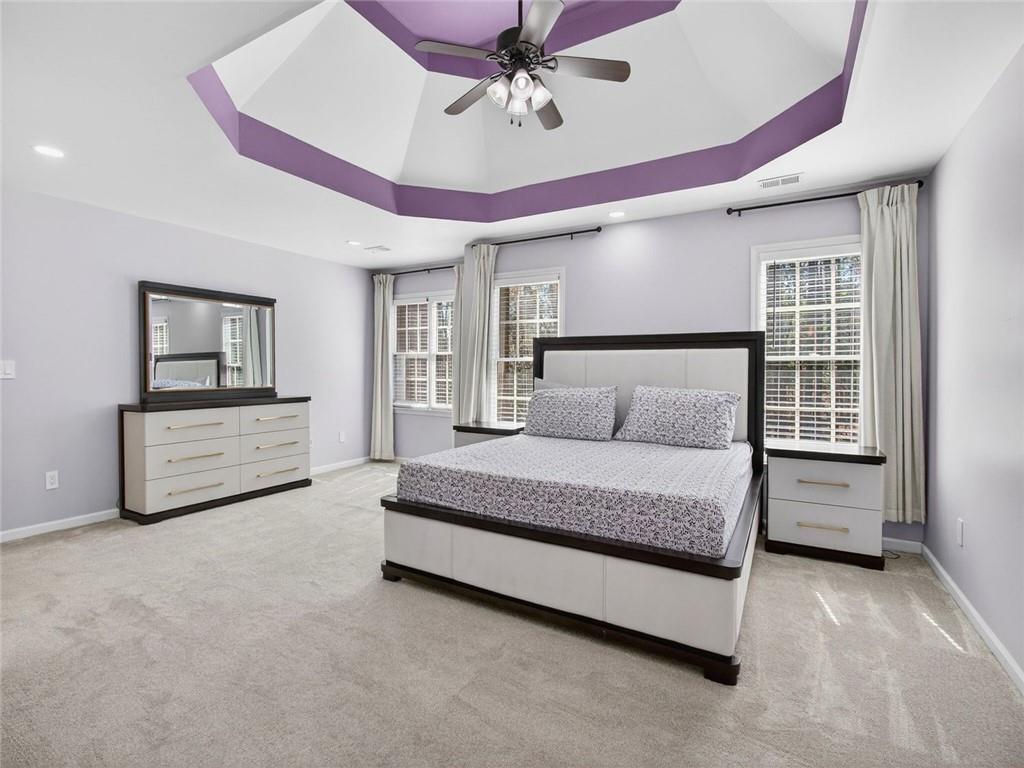 8840 Appling Ridge Cumming, GA 30041 - Photo 36 of 87 a spacious bedroom with a bed a dresser and a chandelier