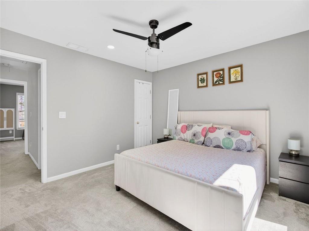 8840 Appling Ridge Cumming, GA 30041 - Photo 46 of 87 a bedroom with a bed and a chandelier