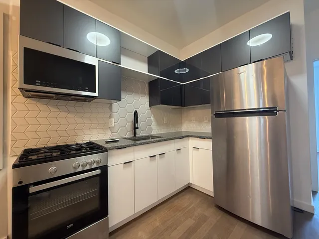a kitchen with stainless steel appliances a refrigerator stove and microwave