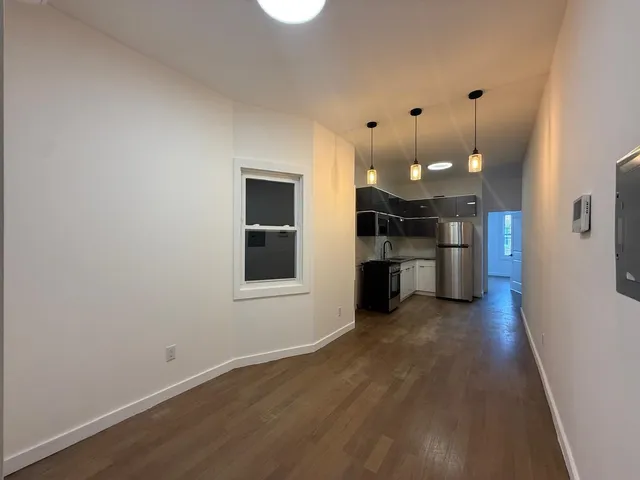 a view of a kitchen with a sink wooden floor and a window