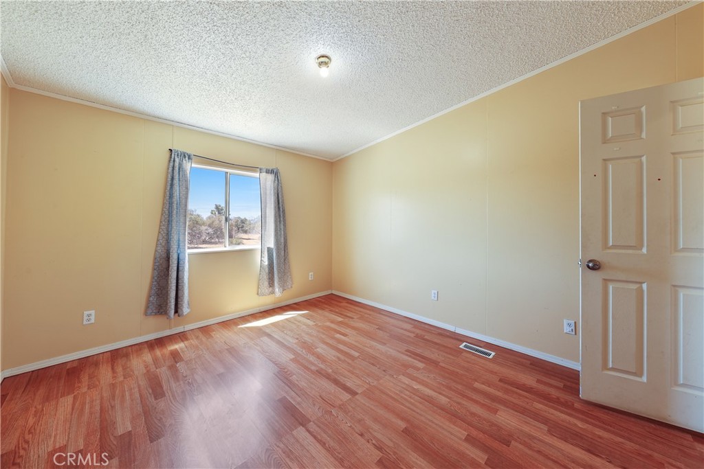 8195 Alta Mesa Road Oak Hills, CA 92344 - Photo 11 of 33 wooden floor in an empty room with a window