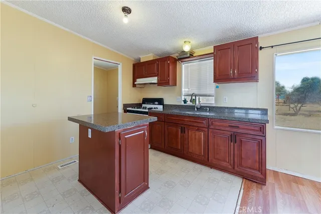 a kitchen with stainless steel appliances granite countertop a stove a sink and a refrigerator