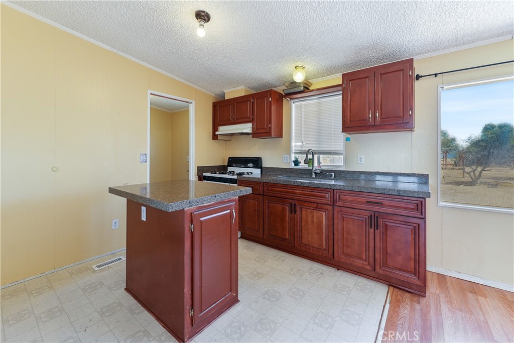 8195 Alta Mesa Road Oak Hills, CA 92344 - Photo 8 of 33 a kitchen with stainless steel appliances granite countertop a stove a sink and a refrigerator