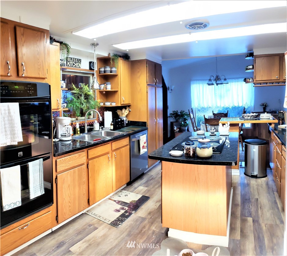 49 Sand Flat Road Omak, WA 98841 - Photo 11 of 40 a kitchen with stainless steel appliances granite countertop a stove a sink and a refrigerator