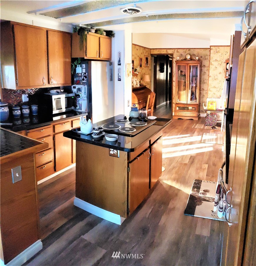 49 Sand Flat Road Omak, WA 98841 - Photo 13 of 40 a kitchen with stainless steel appliances granite countertop a stove a refrigerator and a dining table view