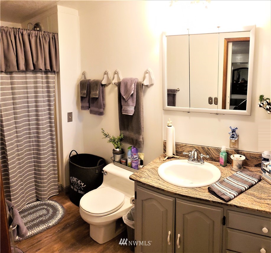49 Sand Flat Road Omak, WA 98841 - Photo 22 of 40 a bathroom with a sink toilet mirror and vanity