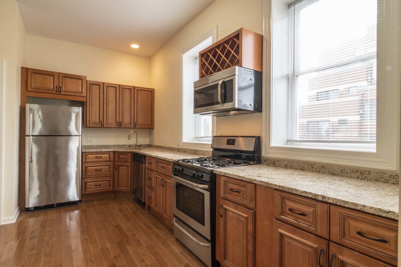 1761 West Augusta Boulevard, Unit 2F Chicago, IL 60622 - Photo 2 of 5 a kitchen with stainless steel appliances granite countertop a stove a sink and a refrigerator