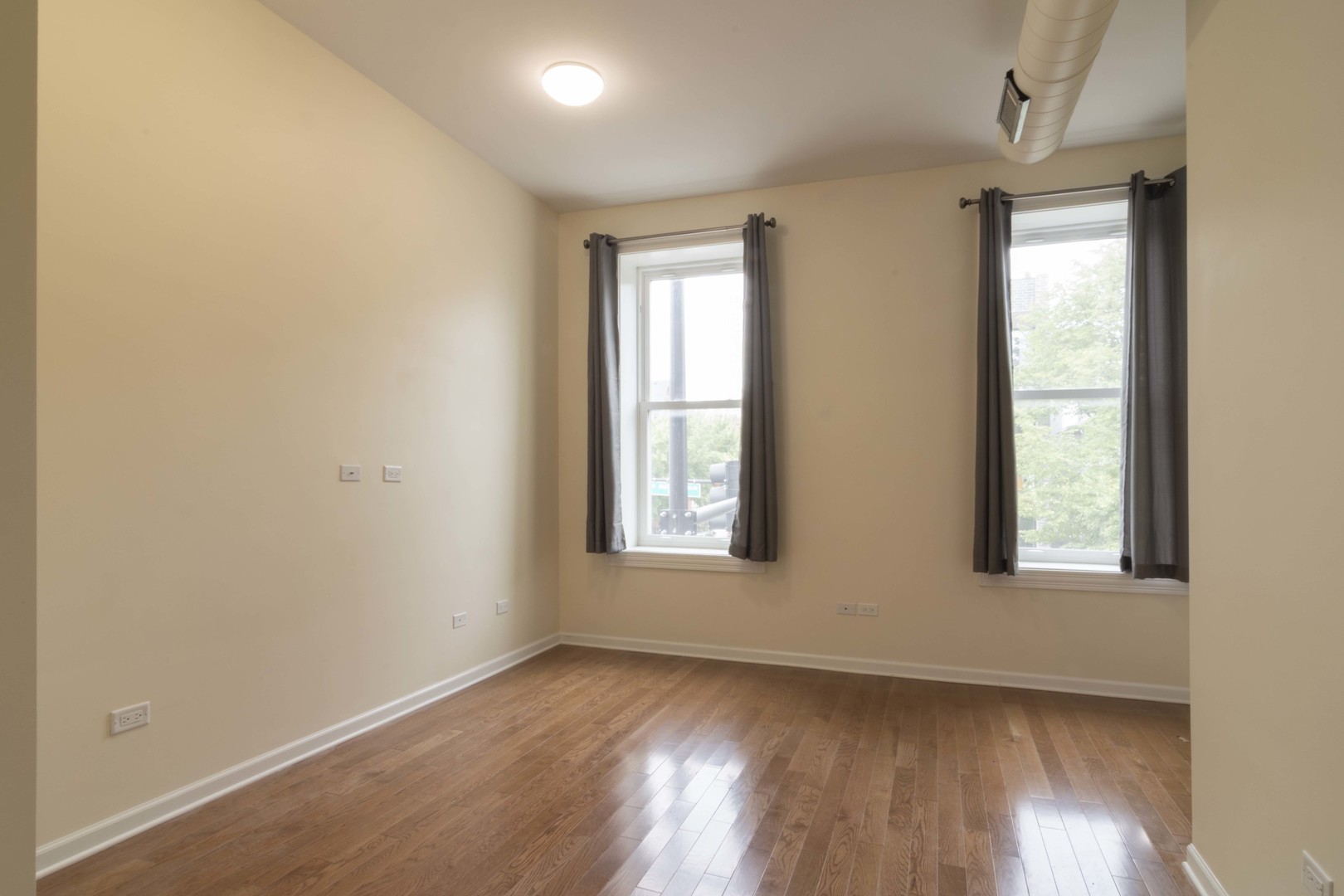 1761 West Augusta Boulevard, Unit 2F Chicago, IL 60622 - Photo 4 of 5 an empty room with wooden floor and windows