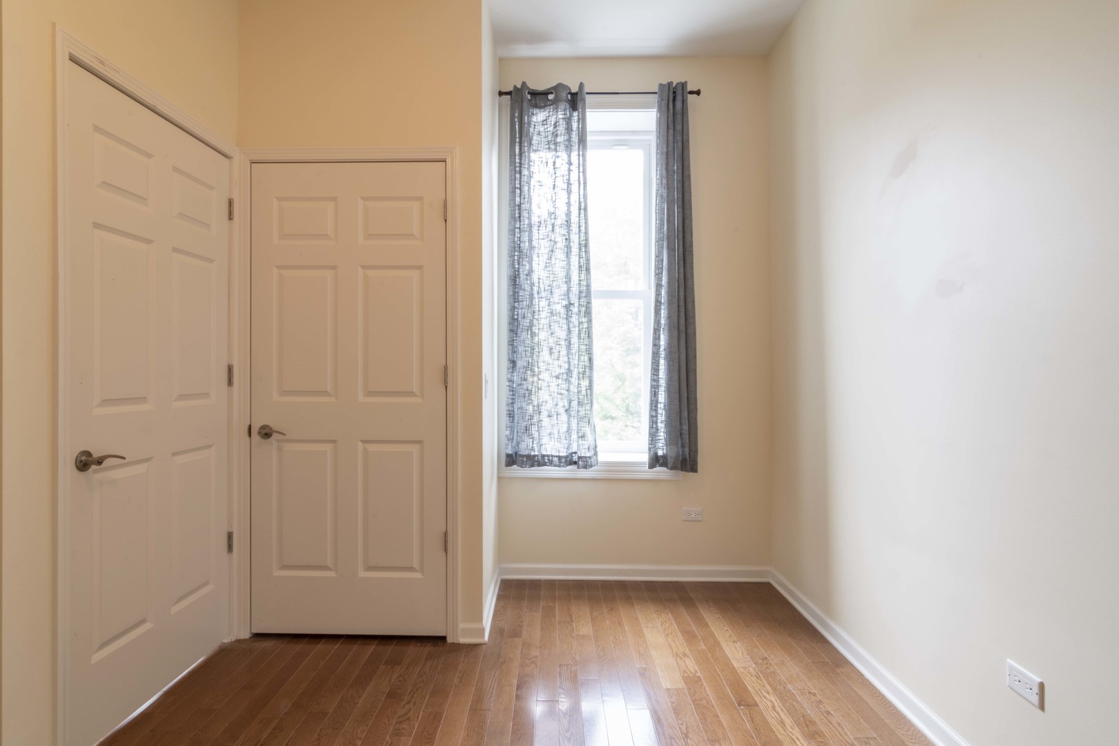 1761 West Augusta Boulevard, Unit 2F Chicago, IL 60622 - Photo 5 of 5 an empty room with wooden floor and windows